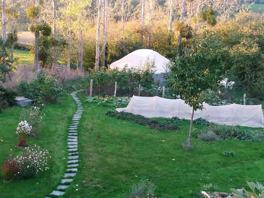 a garden with a stone path in the grass at La yourte au fonds du jardin in Xhoris