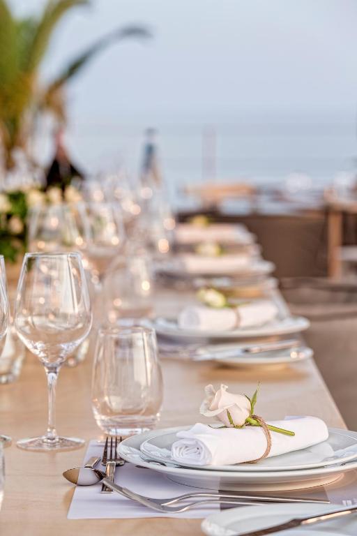 a long table with plates and wine glasses at Horizon Blu Boutique Hotel in Kalamata