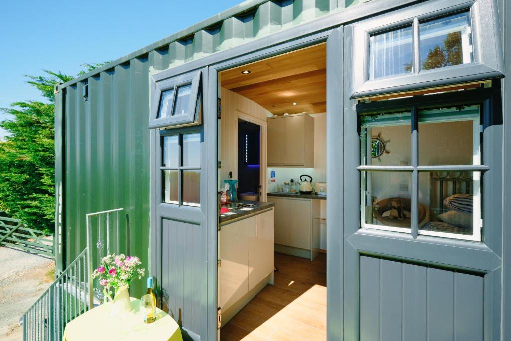 a green shipping container with a kitchen inside of it at Mount View Overnight Accommodation in Penzance