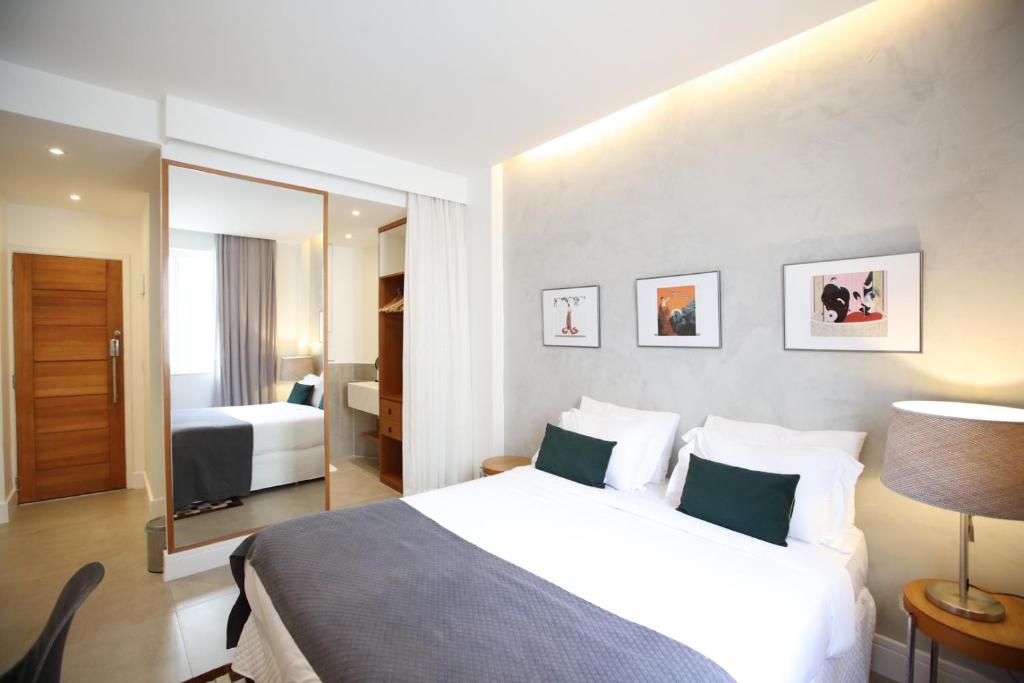 um quarto de hotel com uma cama e um espelho em Unhotel - Aluguel de Temporada Avenida Atlantica, Posto 6 - Praia de Copacabana no Rio de Janeiro