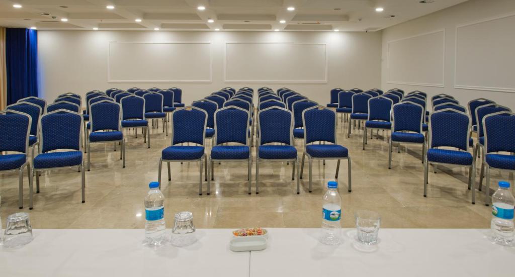 a room with blue chairs and water bottles on a table at Bellazure Hotel in Akyarlar