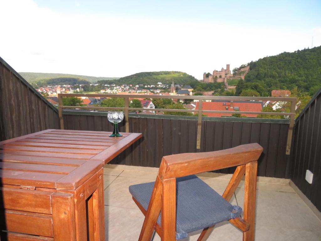 een houten tafel en een stoel op een balkon bij Ferienwohnung Panorama in Wertheim