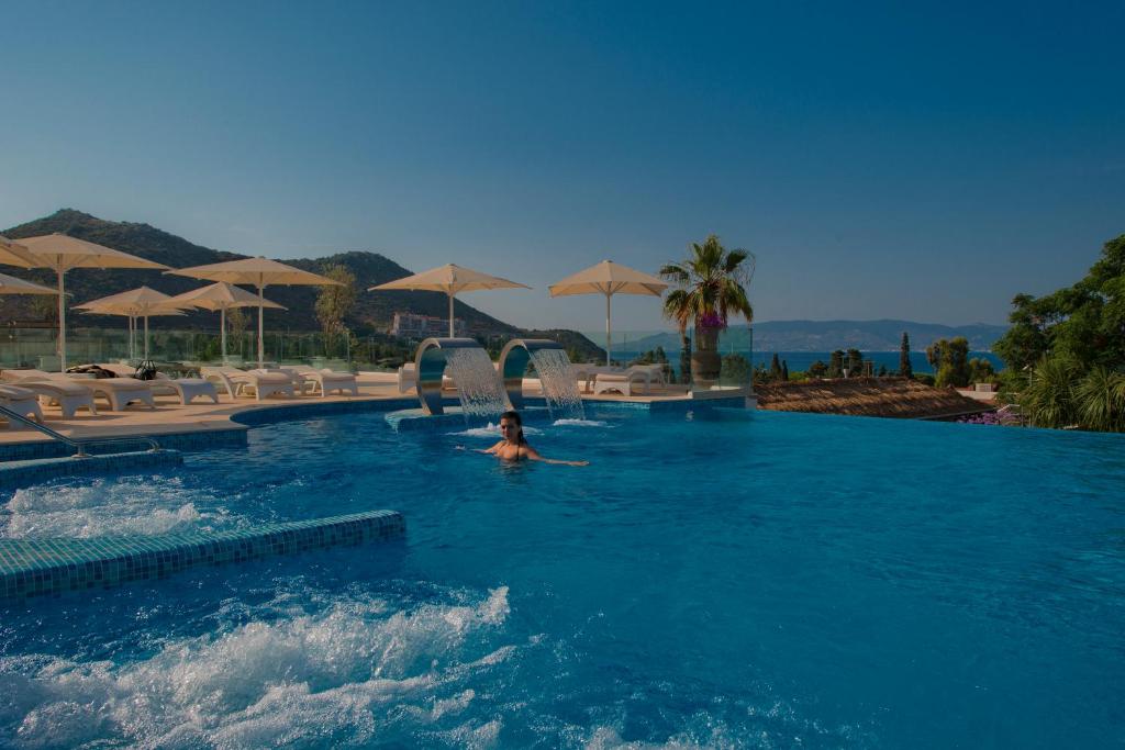 a person in a swimming pool at a resort at Bellazure Hotel in Akyarlar