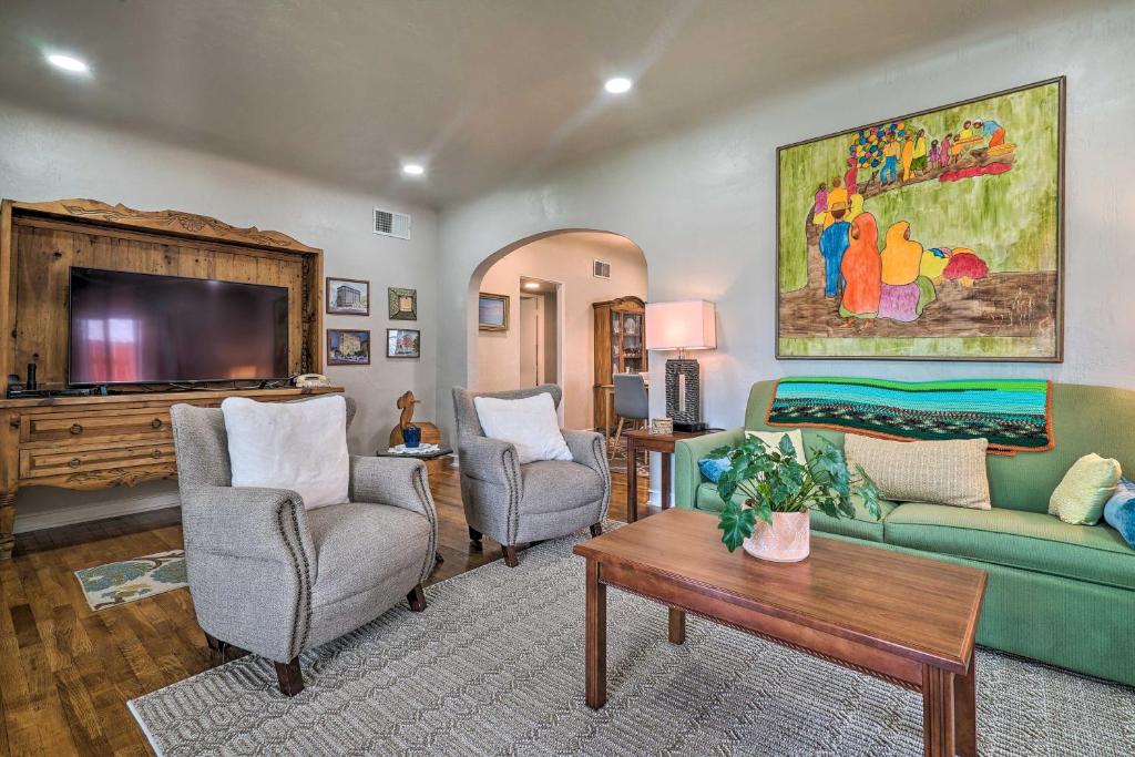 ein Wohnzimmer mit 2 Stühlen und einem TV in der Unterkunft Renovated 1940s Home with Patio and Backyard! in El Paso