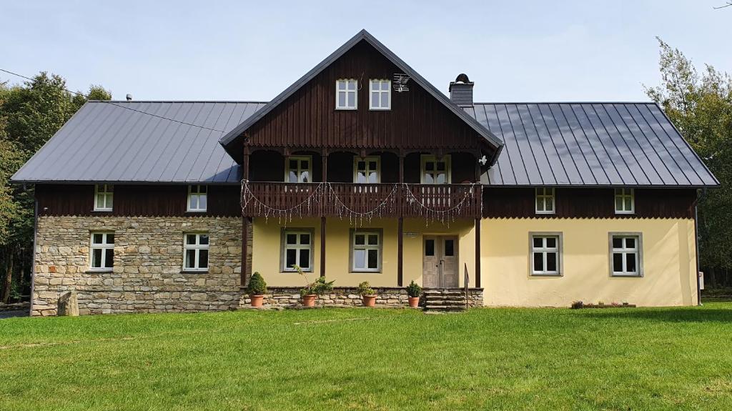 ein Haus mit einem schwarzen Dach auf einem Grasfeld in der Unterkunft Uspokój Ducha in Stara Morawa