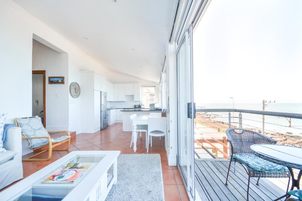 a living room with a view of the ocean at Oceanfront Penthouse in Muizenberg
