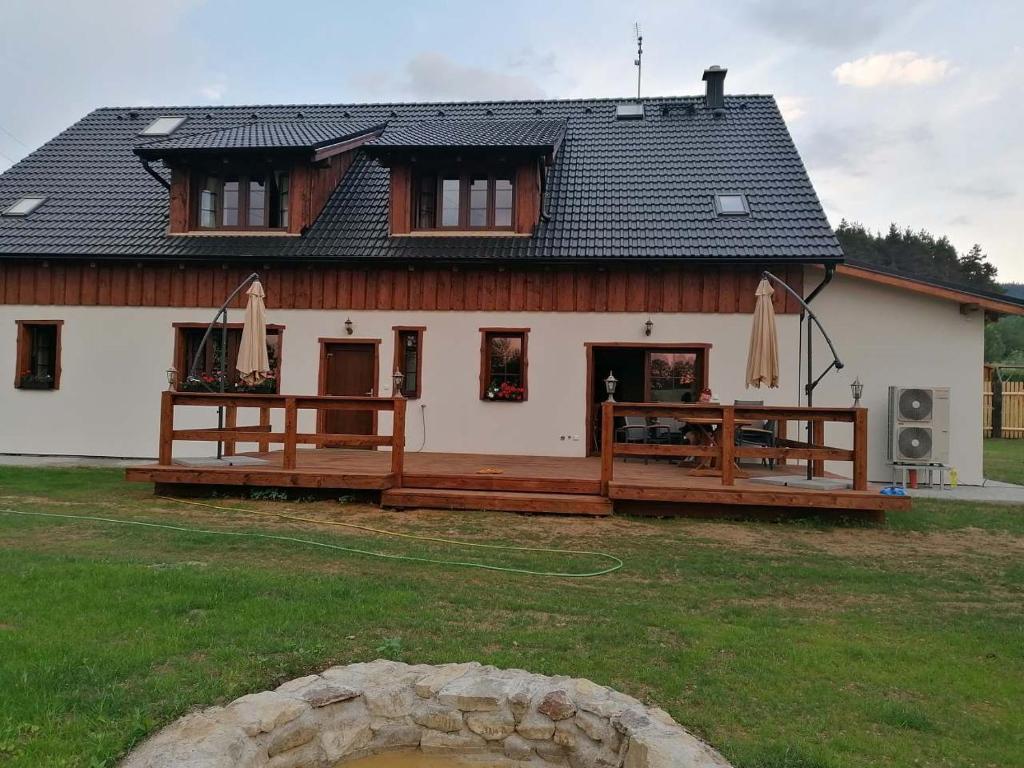 a house with a large deck in front of it at Penzion U Anděla in Zdíkov