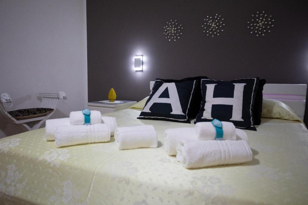 un letto con asciugamani e un cuscino con la parola alleato di Angel House a Bari