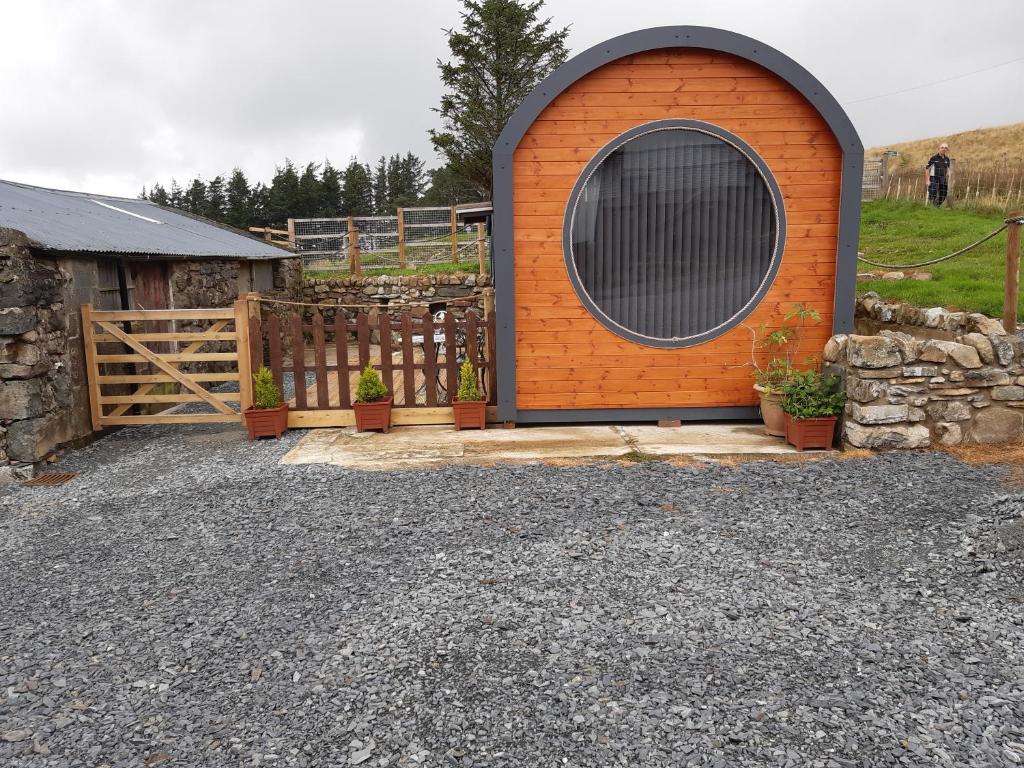 an orange building with a large window next to a fence at Penystryd in Trawsfynydd