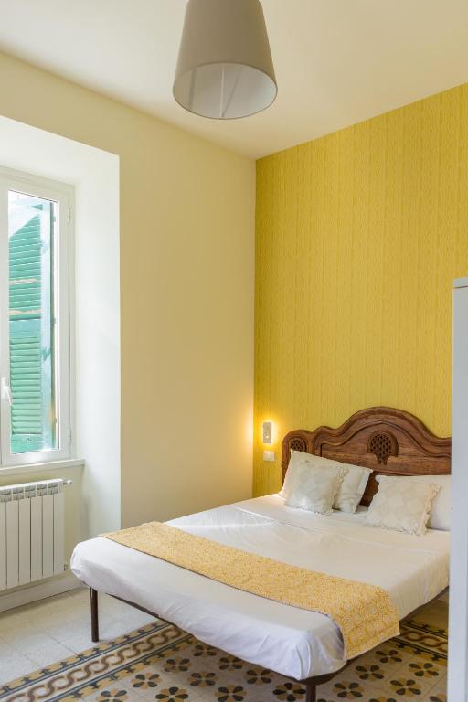 sypialnia z łóżkiem i żółtą ścianą w obiekcie RomAntica Family Apartment near San Giovanni w Rzymie