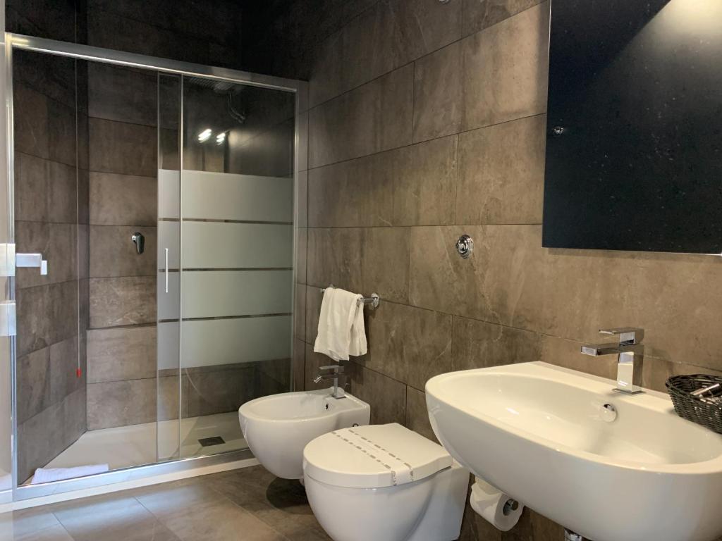 a bathroom with a toilet and a sink and a shower at Neko Boutique Hotel in Cagliari