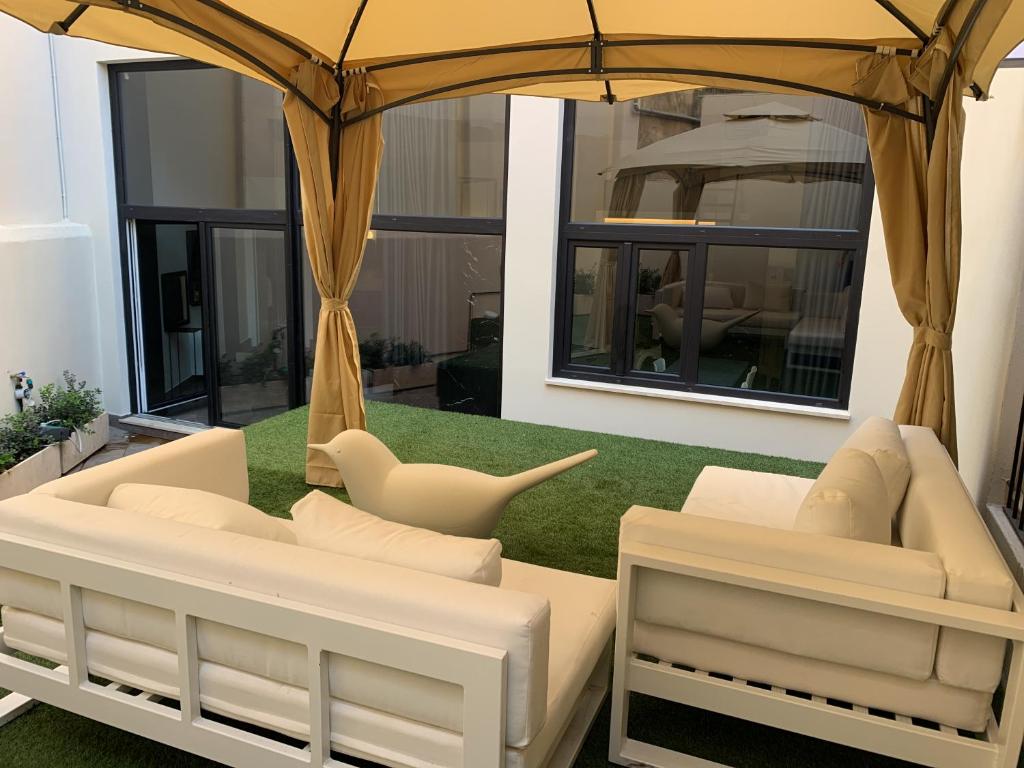 a living room with white couches and an umbrella at Neko Boutique Hotel in Cagliari