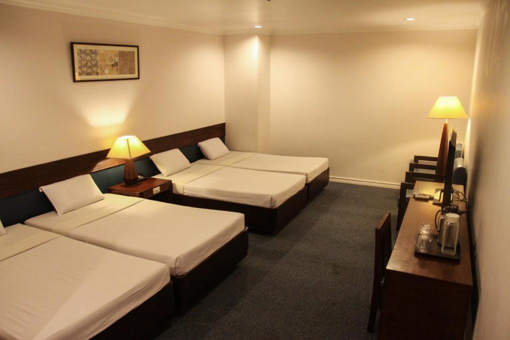 Ένα ή περισσότερα κρεβάτια σε δωμάτιο στο De Luxe Hotel
