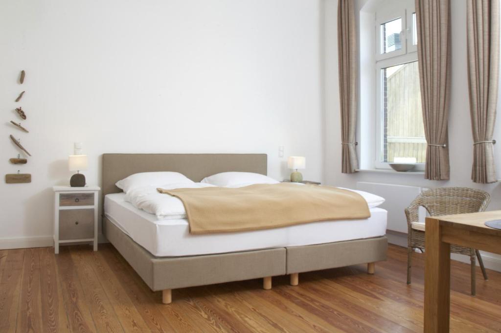 a bedroom with a bed and a table and a window at Ferienwohnungen Schlei 42 in Schleswig
