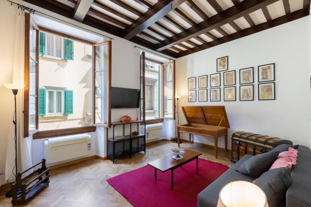 uma sala de estar com um sofá e uma televisão em il Vecchio Baule - Santa Maria Novella em Florença