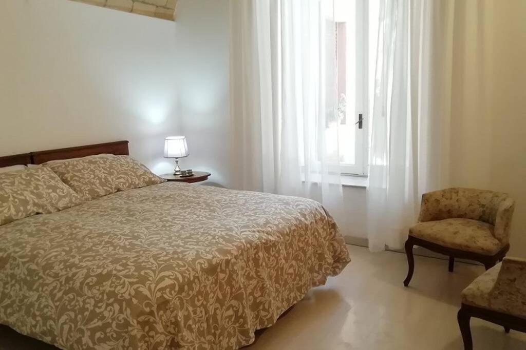 a bedroom with a bed and a chair and a window at La casa della mia famiglia in Rome