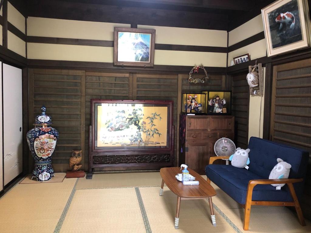 a living room with a blue couch and a table at Fukurou no Oyado - Vacation STAY 71246v in Fuefuki