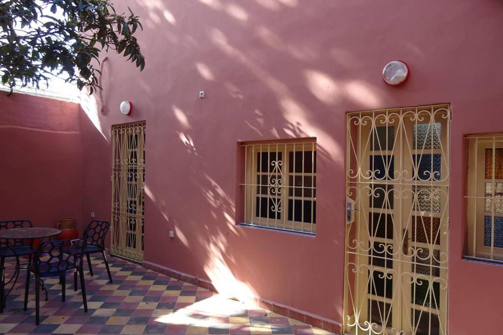 un bâtiment rose avec des portes, une table et des chaises dans l'établissement Large House in Tangiers with Garage, à Tanger
