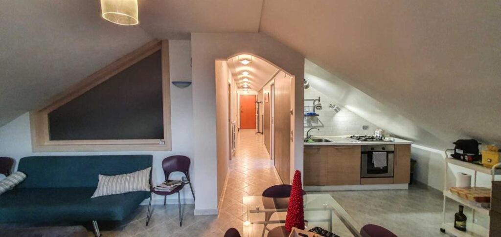 a living room with a blue couch and a kitchen at Artemide Residence in Isernia