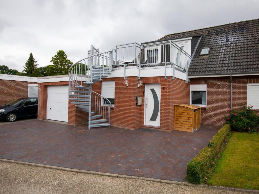 a brick house with a staircase on the side of it at Ferienwohnung am Starenkasten in Berumbur