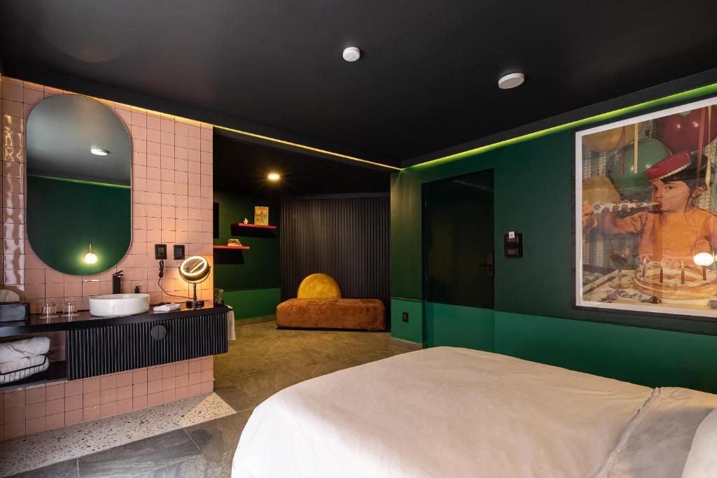 a bedroom with a bed and a bathroom with a sink at Casa Nada Hotel in Guanajuato