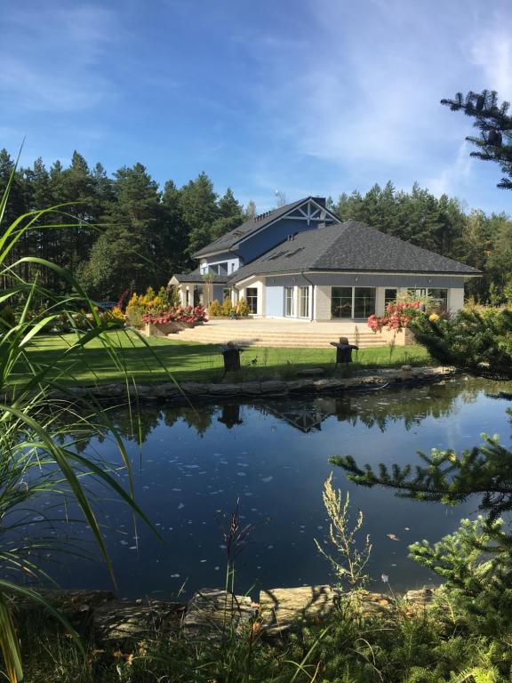 a house with a pond in front of it at Dolcevita Podlasie in Bondary