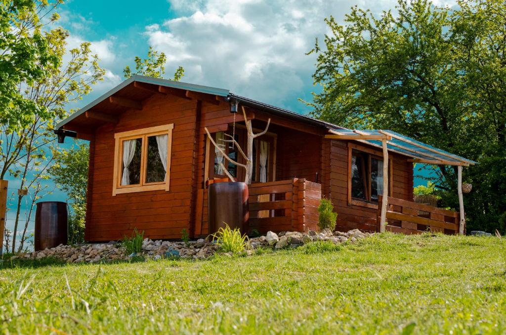 ein kleines Holzhaus auf einem Grasfeld in der Unterkunft Cozy wood hut on the farm in Třebívlice