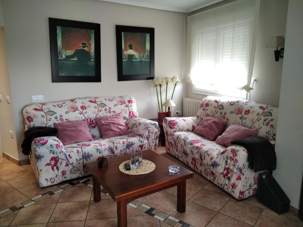 a living room with two couches and a table at Casa Lahuerta 2 in Bronchales