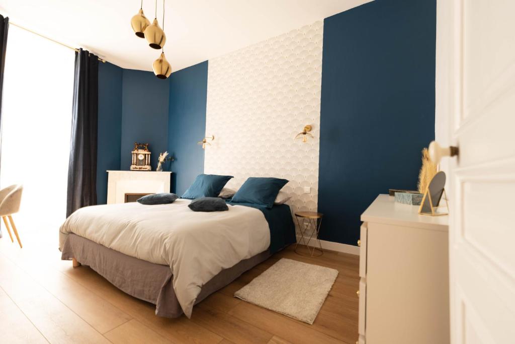 Hotel Le Cannois, a bedroom with blue walls and a bed with blue pillows at Le Cannois in Cannes