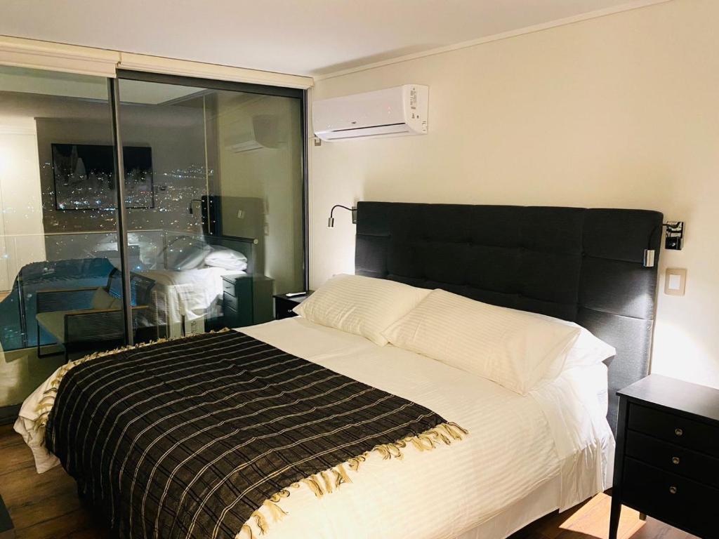 a bedroom with a large bed with a black headboard at Arauco Premium Suite in Santiago