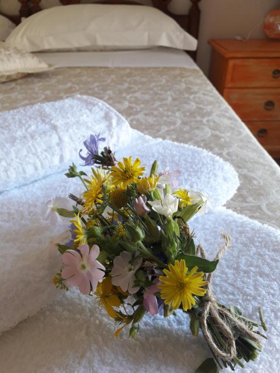 a bouquet of flowers sitting on top of a bed at Agriturismo L'Arco in Guarcino