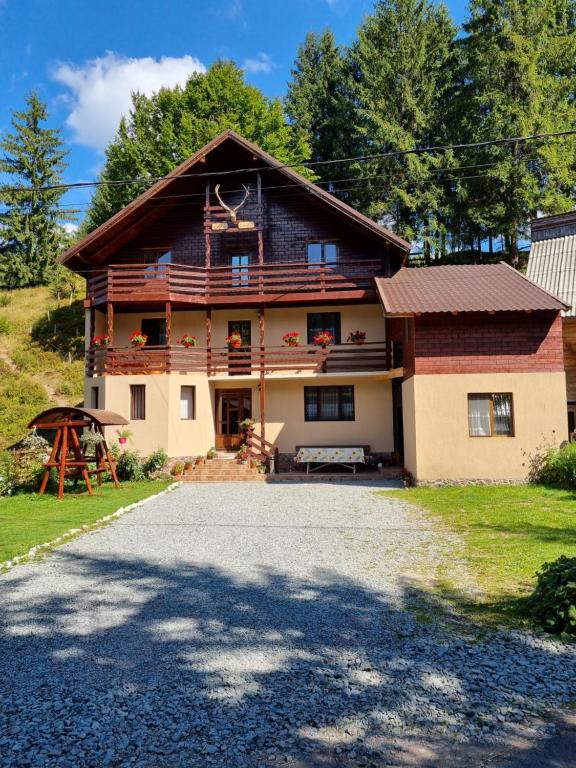 une maison avec une allée en gravier en face de celle-ci dans l'établissement Casa Cerbu, à Arieşeni