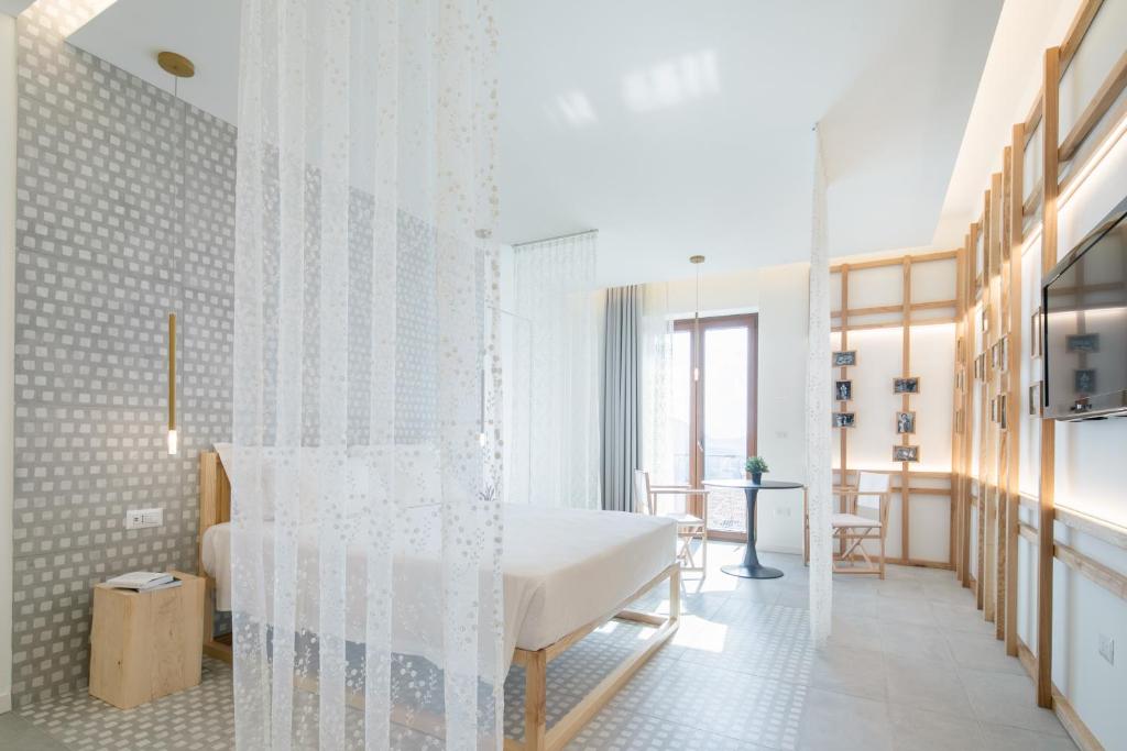 - une chambre blanche avec un lit et une salle à manger dans l'établissement Terra del Sasso Suites - Free Wifi e Netflix, à Sasso di Castalda