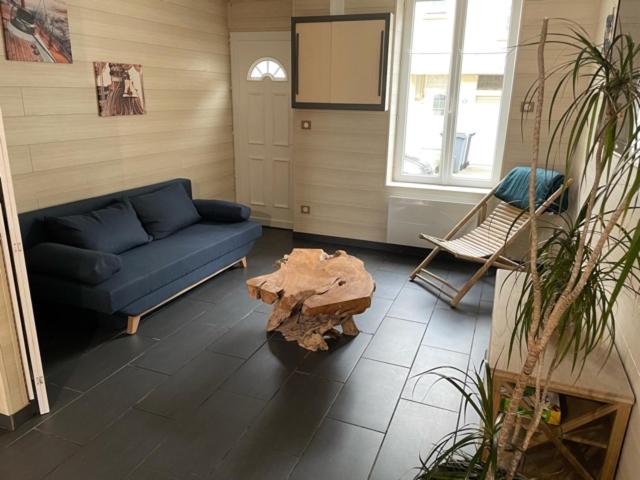 een woonkamer met een blauwe bank en een tafel bij L'ESCALE in Le Portel