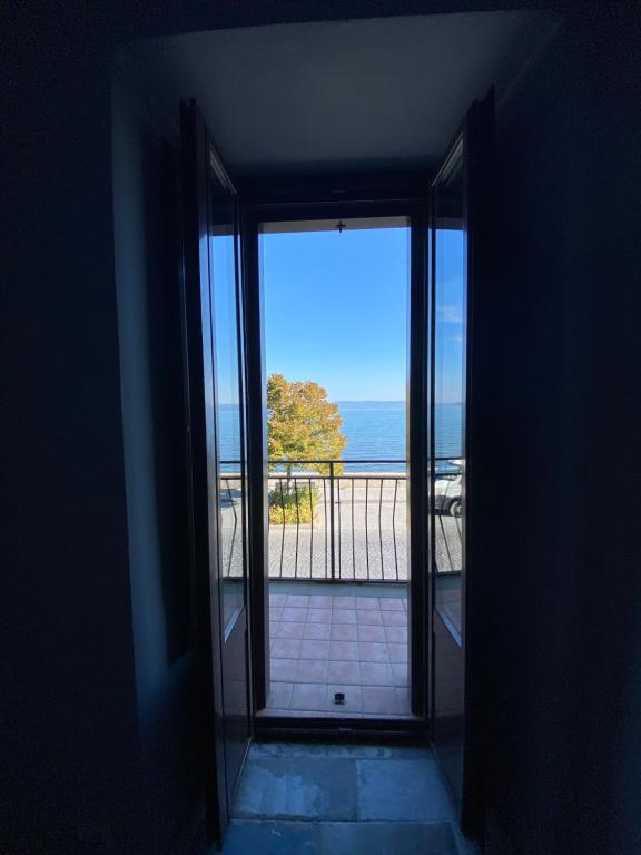 une porte ouverte s'ouvrant sur un balcon avec vue sur l'océan. dans l'établissement La FINESTRA SUL LAGO DI BOLSENA, à Marta