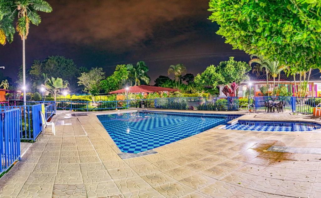 a swimming pool in a park at night at Finca Hotel El Tizon in Quimbaya