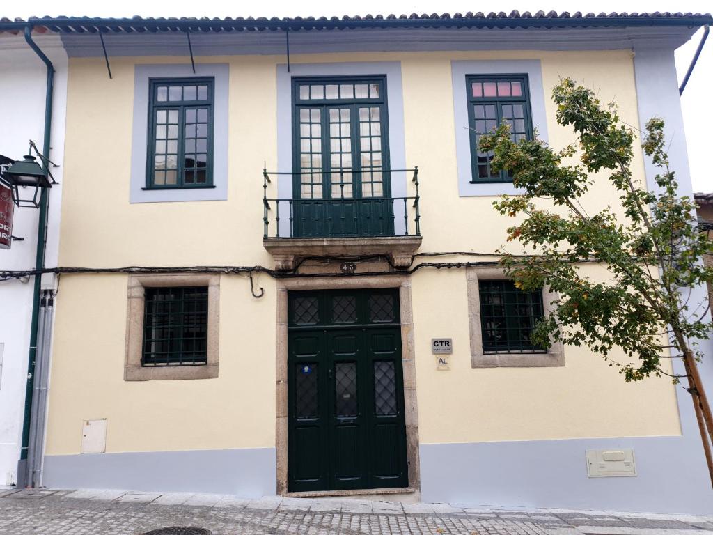 ein Haus mit einer grünen Tür und einem Balkon in der Unterkunft CTR Guest House in Guimarães