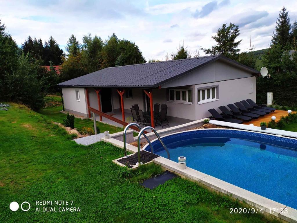 a small house with a swimming pool in the yard at Holiday home in Svahova - Erzgebirge 41640 in Svahová