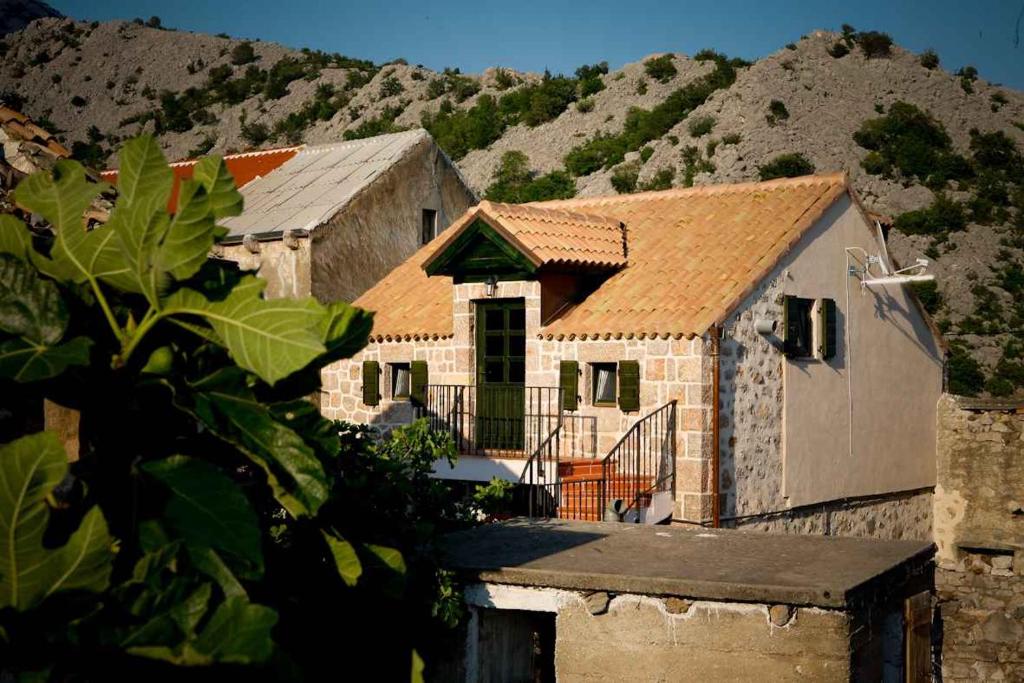 mały ceglany dom z górą w tle w obiekcie Holiday home in Starigrad-Paklenica 41708 w mieście Starigrad-Paklenica