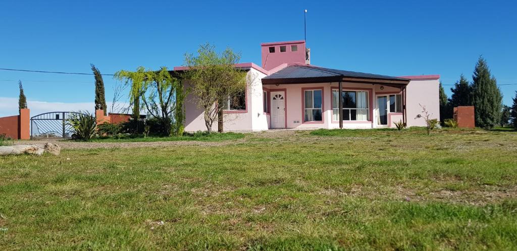 a house with a grassy field in front of it at Las Condalias in Puerto Madryn