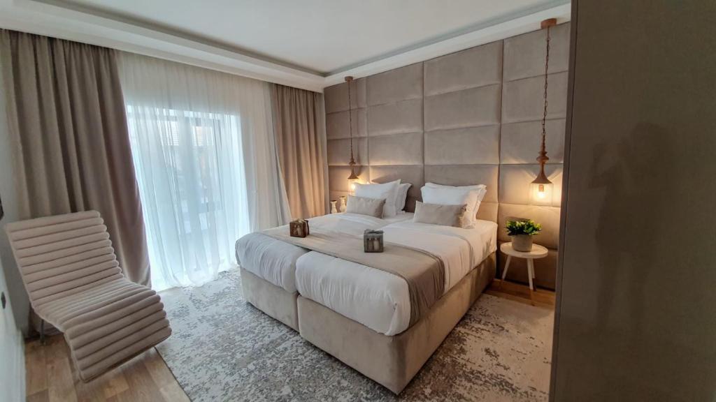 a bedroom with a large bed and a chair at The Berg's 3 in Ocna-Mureşului
