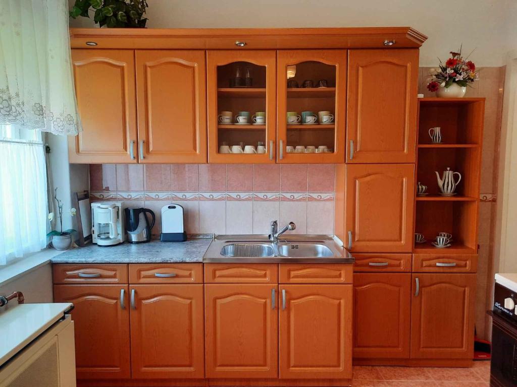 een keuken met oranje kasten en een wastafel bij Apartments in Siofok - Balaton 41945 in Siófok