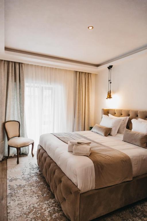 a bedroom with a large bed with a chair and a window at The berg's 2 in Ocna-Mureşului