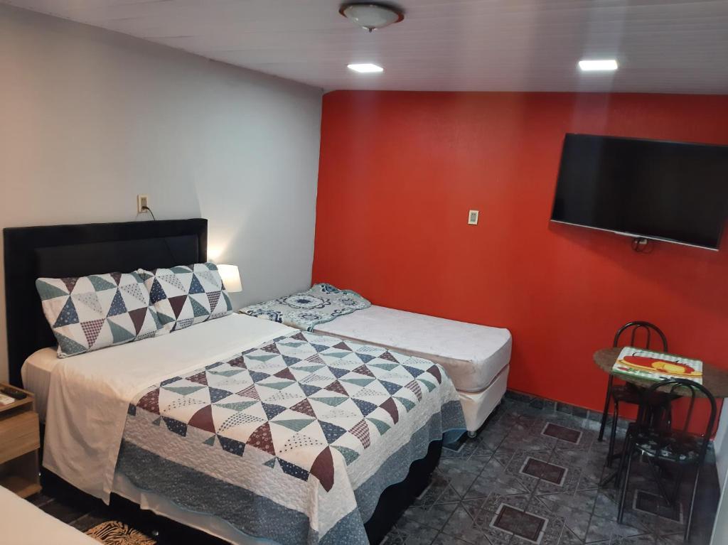 a bedroom with a bed and a flat screen tv at Hospedaje al inicio de la Costanera in Encarnación