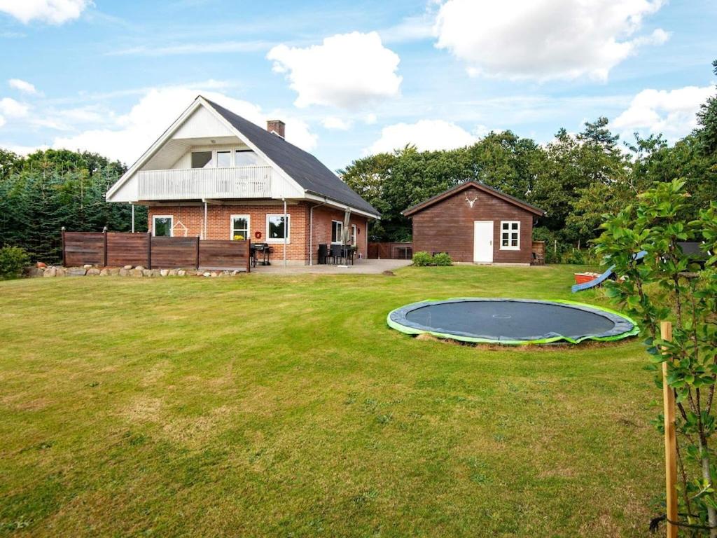 a house with a trampoline in the yard at 8 person holiday home in Ringk bing in Ringkøbing