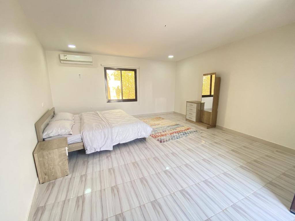 a bedroom with a bed and a wooden floor at Desert Dune Farmhouse - By Seven Elements in Ras al Khaimah
