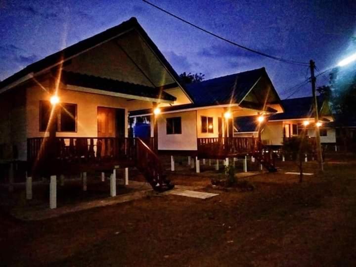 una casa con porche por la noche con luces en ทับบีช เนเชอรัล รีสอร์ท 