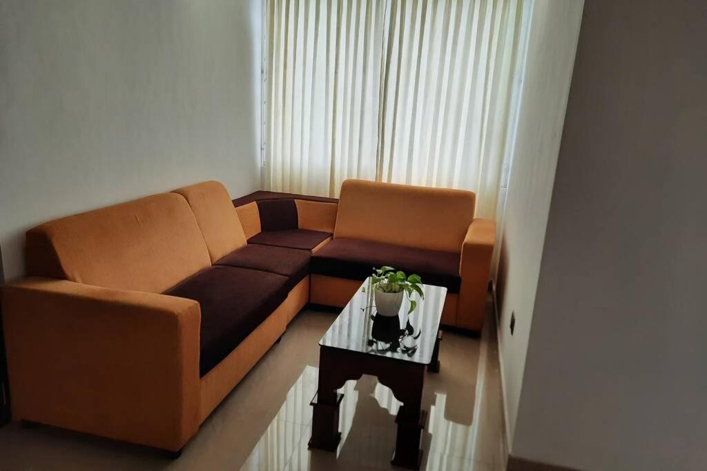 sala de estar con sofá y mesa de centro en BMRAN Apartment A en Ernakulam