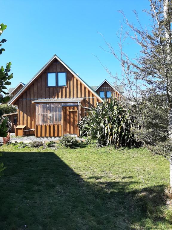 una gran casa de madera con un patio verde en The Gables B&B en Ohakune