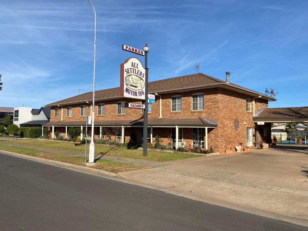 a building with a sign on the side of a street at All Settlers Motor Inn Parkes in Parkes